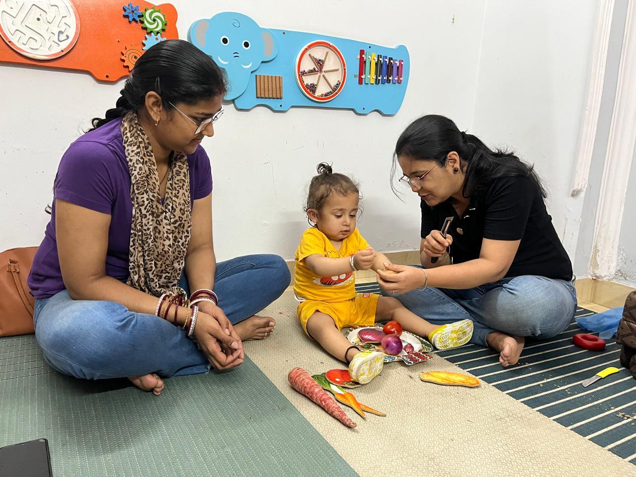 A child in a play-based therapy session with a therapist and parent
